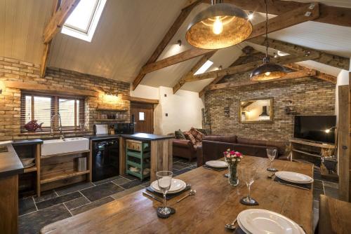Una cocina y una sala de estar con una mesa de madera. en Lavender - Luxurious Barn Conversion - Blossom Farm, en Johnston