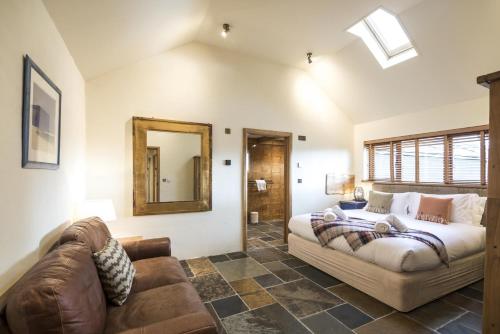 un dormitorio con una cama y un sofá en Lavender - Luxurious Barn Conversion - Blossom Farm, en Johnston