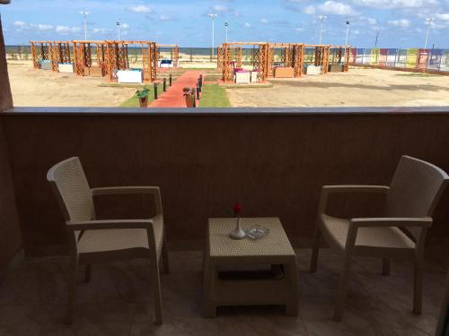 two chairs and a table with a view of a beach at Jewel Gameel appartement in Port Said