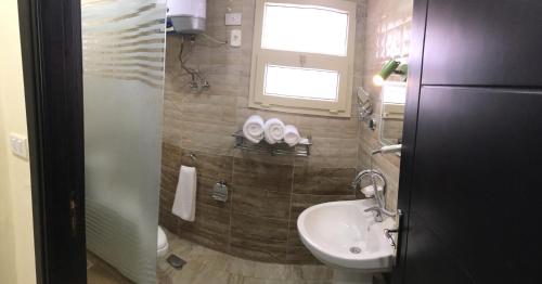 bagno con lavandino, servizi igienici e finestra di Jewel El Gameel Hotel a Port Said