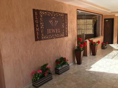 a lobby with potted plants and a sign on a wall at Jewel Gameel appartement in Port Said