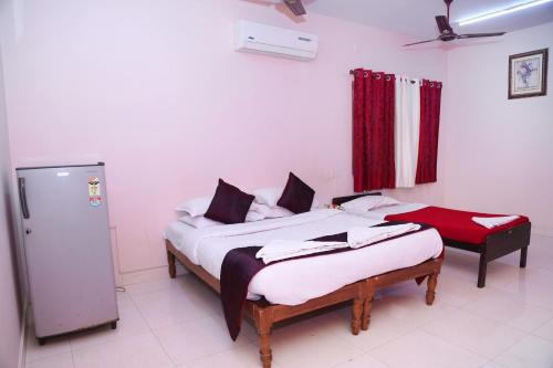 a bedroom with two beds and a refrigerator in it at DAFFODILS SERVICED APARTMENT in Chennai