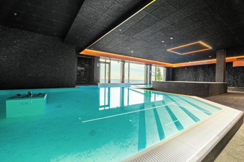 a large swimming pool with blue water in a building at Hotel Iso-Syöte in Syöte