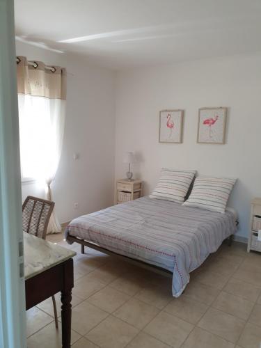 Habitación blanca con cama y ventana en Gîte Bastide LAGREMUSE, en Sarrians