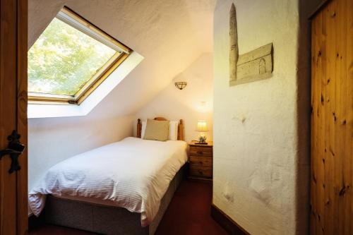 a small bedroom with a bed and a window at Tudor Lodge in Laragh