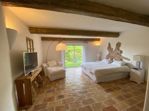 een slaapkamer met een groot bed en een televisie bij VILLA EN PIERRE in Vence