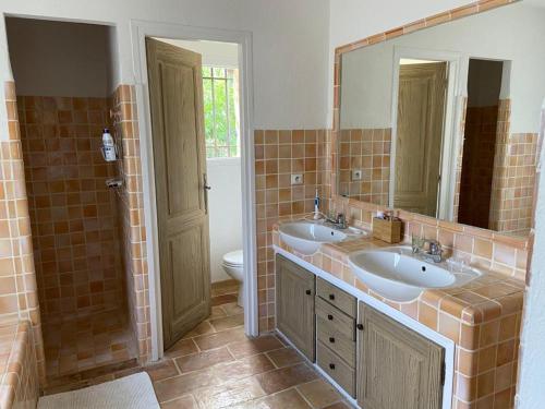 une salle de bain avec deux lavabos et un WC et un miroir dans l'établissement VILLA EN PIERRE, à Vence