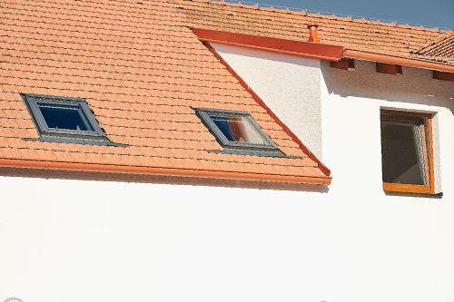 two windows on a building with an orange roof at Apartmán NEWSTALGIE in Mikulov