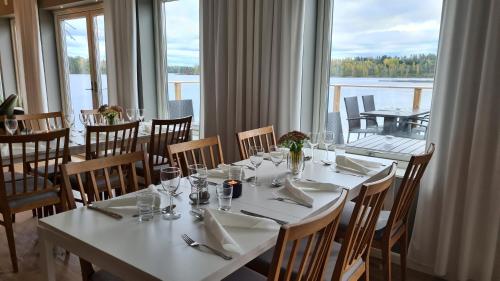 a dining room with tables and chairs and a large window at Håveruds hotell och konferens in Håverud