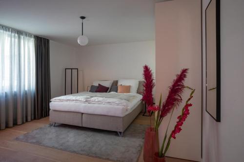 a bedroom with a bed and a vase with flowers at MUNICH FINEST APARTMENTS in Munich
