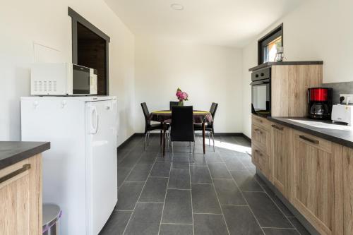 a kitchen with a table and a white refrigerator at Le nid breton in Lézardrieux