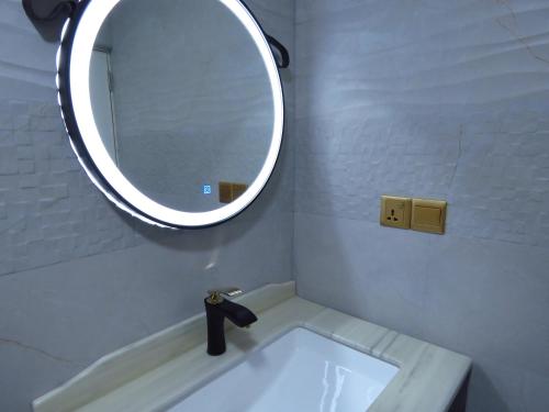 a bathroom with a sink and a mirror at The Sunrise Huraa in Huraa