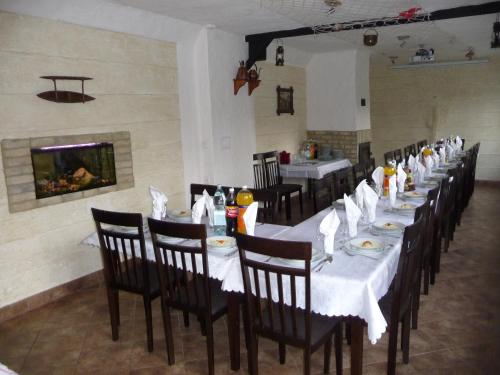 a dining room with tables and chairs and a fireplace at Motel Maria in Szałe