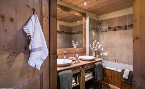 uma casa de banho com 2 lavatórios e um espelho grande em Résidence l'Oxalys em Val Thorens