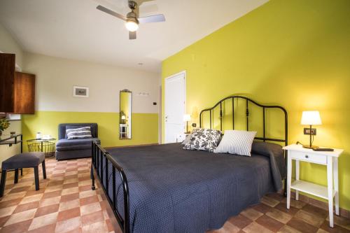a bedroom with a large bed and a chair at Torrenova di Assisi Country House in Assisi
