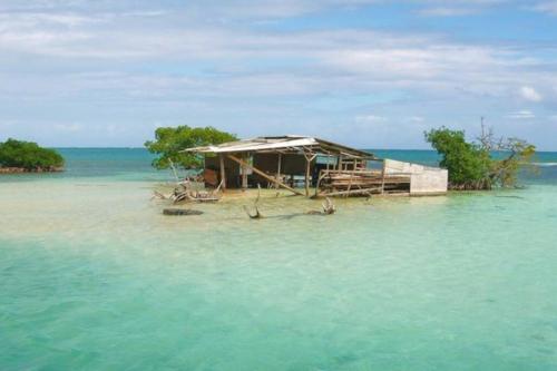 a house on a small island in the water at Maison 80 m2 super vue montagne piscine 2 chambres in Goyave