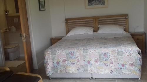 a bedroom with a bed with a quilt on it at Harris End in Lancaster