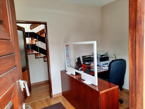 an office with a desk with a computer and a mirror at Maia Oporto Suites in Maia