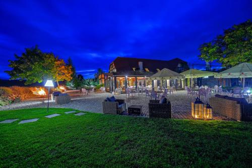 a patio with tables and chairs at night at BORECZNA in Michałkowa