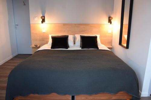 a bedroom with a large bed with a wooden headboard at nuit sur le pont 5 in Landerneau