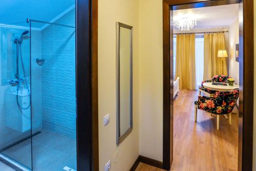 a bathroom with a glass shower and a table at Villa Boutique Alina in Deva