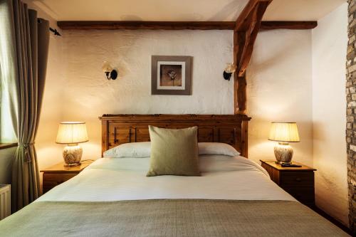 a bedroom with a large bed with two lamps at Tudor Lodge in Laragh