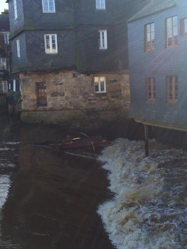 a house and a river with snow in front of it at nuit sur le pont 5 in Landerneau