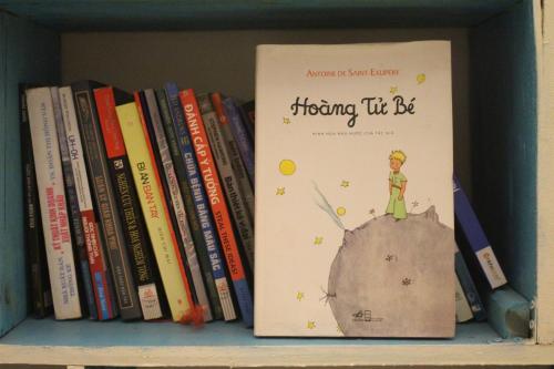 a book sitting on a shelf with books at Bụi Hostel - Ferry to Rạch Giá in Rach Gia