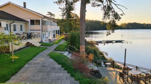 een huis aan de oever van een meer bij Håveruds hotell och konferens in Håverud