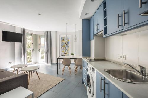 une cuisine avec un évier et un salon dans l'établissement Stancia Carmen, à Valence