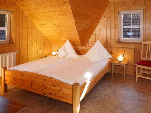 een slaapkamer met een bed in een houten kamer bij Hinterbauer Hof in Oberharmersbach