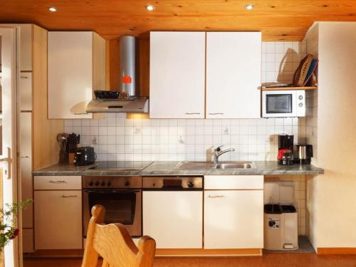a kitchen with white cabinets and a sink at Hinterbauer Hof in Oberharmersbach