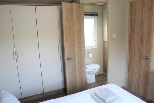 a bathroom with a bed and a toilet and a window at Newquay Bay Resort - Spacious - Sleeps 6 - Close to Porth Beach in Newquay