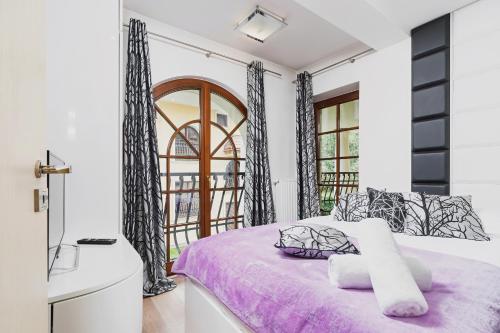 een slaapkamer met een paars bed en een raam bij Apartament Neapol Rezydencja Sienkiewicza by Renters in Zakopane