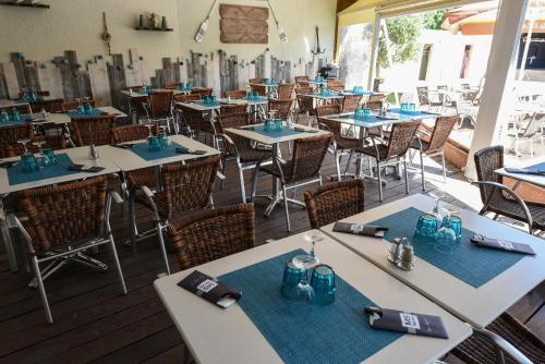 an empty restaurant with blue tables and chairs at Camping Club Le Littoral - Maeva in Argelès-sur-Mer