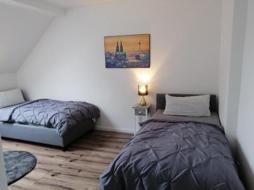 een slaapkamer met 2 bedden en een lamp erin bij Kölsche Wohnung 1C in Keulen