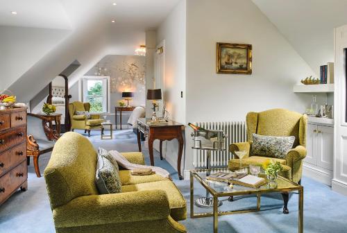 a living room with yellow chairs and a table at Killarney Randles Hotel in Killarney