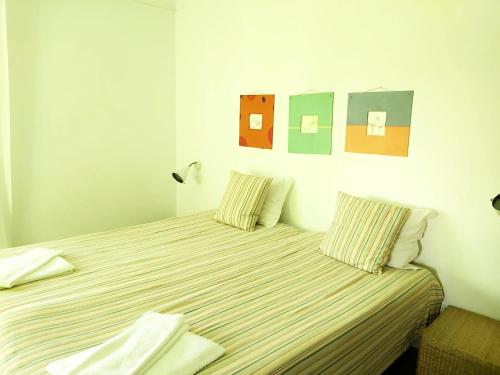 - une chambre avec 2 lits avec des draps rayés dans l'établissement Baby Boom - Duna Parque Group, à Vila Nova de Milfontes