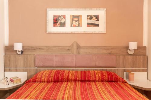 una camera con un letto e due tavoli e una foto di Villa Trilocale sea, natura & relax! ad Albinia