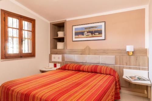 a bedroom with a bed with a orange blanket at Villa Trilocale sea, natura & relax! in Albinia
