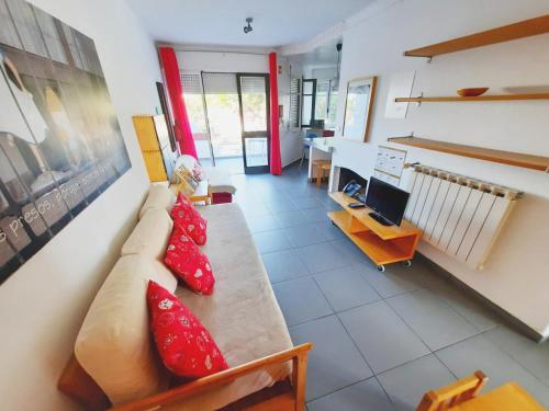 uma sala de estar com um sofá e almofadas vermelhas em Baby Boom - Duna Parque Group em Vila Nova de Milfontes