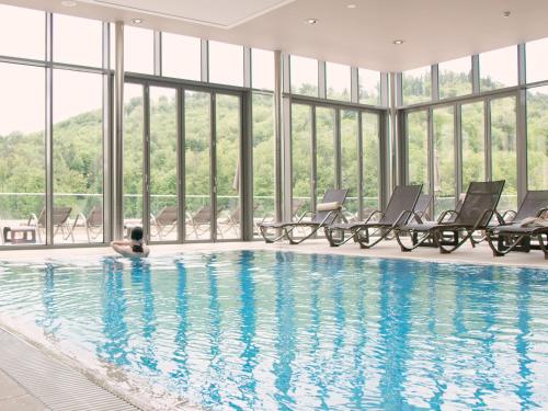 una persona tendida en una piscina en un edificio con ventanas en Atlantida Boutique Hotel, en Rogaška Slatina