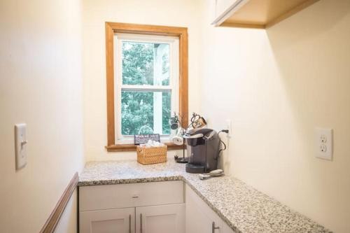 a kitchen with a counter top with a window at The Boston Rental - Multiple Floorplans in Boston