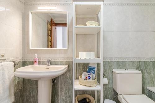 bagno con lavandino, servizi igienici e specchio di Nice Canteras - 2BDR + WiFi + Balcony a Las Palmas de Gran Canaria