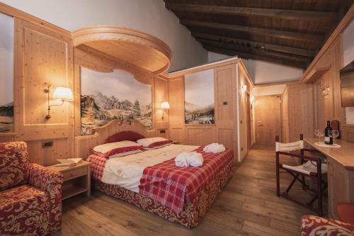 a bedroom with a bed and a table and a desk at Hotel Rubino Deluxe in Campitello di Fassa