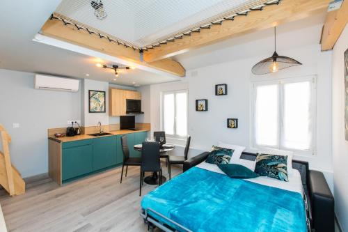 Cet appartement comprend une chambre avec un lit bleu et une cuisine. dans l'établissement Duplex : Plage 300m, Clim, Netflix, à Cannes