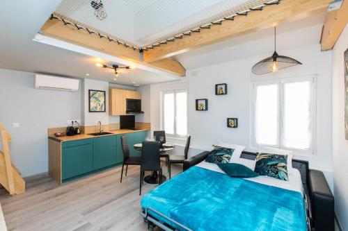 une chambre avec un lit bleu et une cuisine dans l'établissement Duplex : Plage 300m, Clim, Netflix, à Cannes