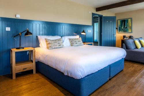 a blue bedroom with a large bed and a couch at The Seagate in Appledore