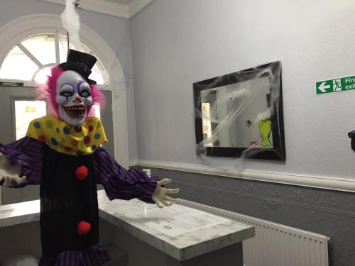 a clown standing in front of a mirror at Queens Guesthouse Manchester in Manchester