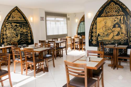 comedor con mesas y sillas de madera en Fenicia Palace Hotel, en Varginha